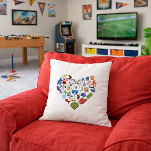 White pillow with colorful heart design on a red couch in a room with toys and arcade games.