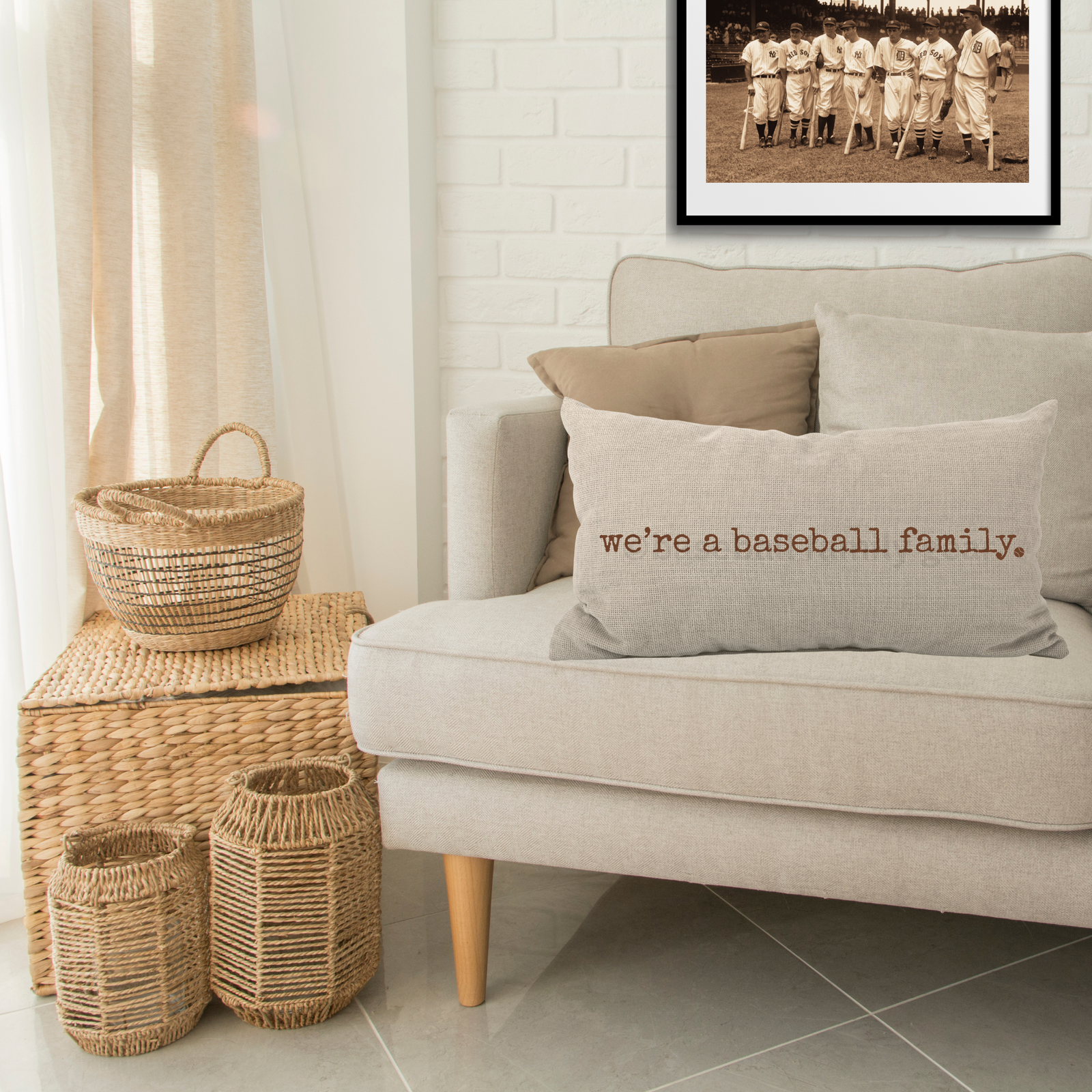 living room sofa with throw pillow that says we're a baseball family in old typewriter font