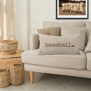 decorative beige pillow in a living room setting with the word baseball in a distressed typewriter font